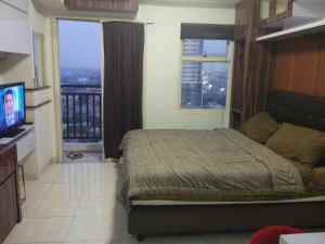 德波DSR马尔贡达2号公寓的一间卧室设有一张床、一台电视和窗户。