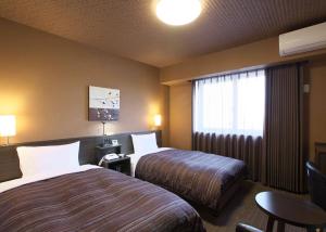 IzumiHotel Route Inn Osaka Izumi -Kishiwada Izumi Inter-的酒店客房设有两张床和窗户。