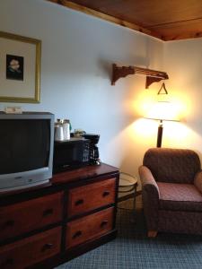 布赖森城岭顶汽车旅馆 - 布赖森城的客厅配有电视、椅子和台灯