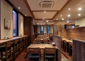 高冈市高冈站前路途酒店 的餐厅设有木桌、椅子和窗户。
