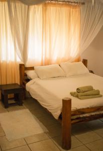 维兰库卢什Vila la Mar Vilanculo的一间卧室设有一张大床和窗户