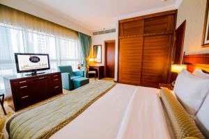 阿布扎比Grand Mercure Abu Dhabi的酒店客房,配有床和电视
