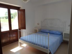克若伯里Country House 3Quatrì的一间卧室配有一张蓝色床单和一个阳台。