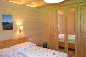 阿亨基希Ferienwohnung Hinterwinkl的木墙客房的两张床
