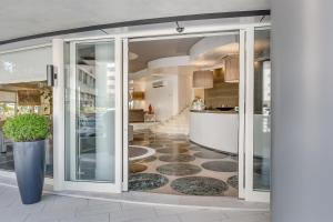 利多迪耶索罗玛丽维尔酒店的走廊设有滑动玻璃门和地板