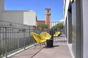 塔拉戈纳Residencia Universitaria Tarragona Mediterrani的阳台上的一排黄色椅子