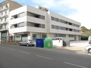 阿尔卡尼斯Apartamentos Mequedo的街道前有车辆停放的建筑物