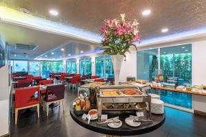 曼谷Anajak Bangkok Hotel - SHA Plus的一间带桌椅的餐厅以及一间自助餐