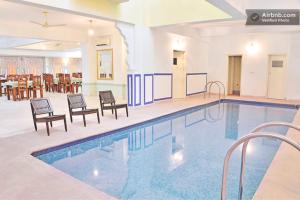 斋浦尔拉尼泰姬陵酒店的大楼内带桌椅的大型游泳池