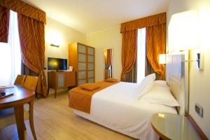 都灵贝斯特韦斯特水晶宫酒店的酒店客房设有一张大床和一张桌子。