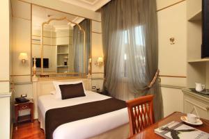 罗马德格里阿蓝希酒店的一间卧室配有一张床、一张桌子和一面镜子