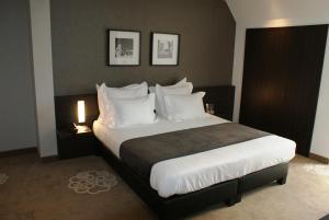 布鲁日Hotel Restaurant Weinebrugge的卧室配有带白色枕头的大床