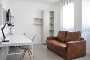 塔拉戈纳Residencia Universitaria Tarragona Mediterrani的客厅配有书桌和真皮座椅。
