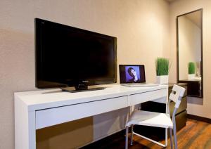 圣何塞阿露拉旅馆的一张带电视和笔记本电脑的白色书桌