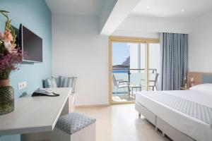 米尔泰Zephyros Hotel的一间卧室配有一张床,享有海景
