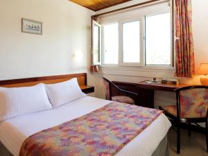 塞威恩罗格斯艾登拉克酒店的一间卧室配有一张床、一张书桌和一个窗户。