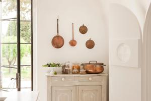 库特罗菲安诺Critabianca - Masseria in Salento的厨房墙上设有铜锅和平底锅