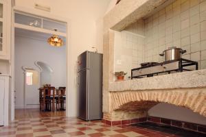 里斯本里斯本客房公寓的厨房配有冰箱,旁边是砖炉