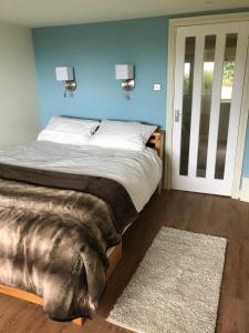 马伯斯One Slade Gardens的一间卧室设有一张床和蓝色的墙壁