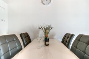 大洛希尼Apartments Relax的一张桌子,上面有酒杯和墙上的时钟