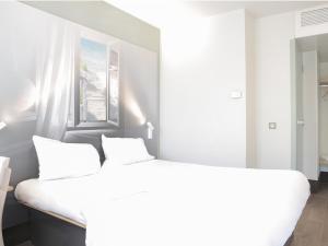 耶尔B&B HOTEL Hyeres的白色的卧室设有一张大床和一个窗户