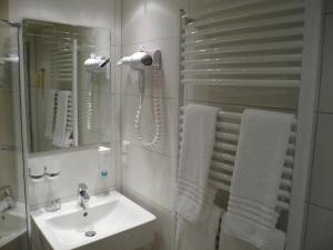 锡格堡凯撒霍夫酒店的白色的浴室设有水槽和镜子
