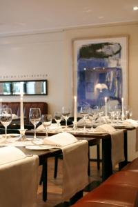 锡格堡凯撒霍夫酒店的用餐室配有带酒杯的长桌