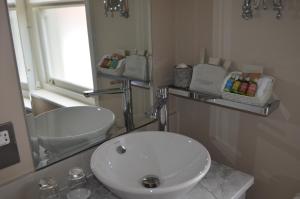 赫里福德城堡别墅酒店的浴室设有白色水槽和镜子