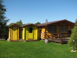 KolkjaKolkja Holiday Centre的一座带栅栏的院子中的黄色房子