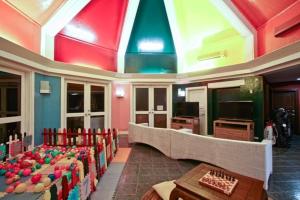 纳苏格布俱乐部蓬富埃戈酒店的客房拥有色彩缤纷的天花板和桌椅。