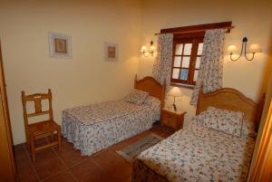 TaibiqueCasa Rural El Roque的一间卧室设有两张床和窗户。