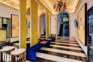 里斯本罗西奥因恩酒店的建筑中带有黄色柱子和蓝色座椅的走廊