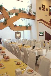 夸察夸尔科斯Hotel Enriquez的宴会厅配有白色的桌子和白色的椅子