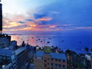 芭堤雅市中心Sunbeam Hotel Pattaya - SHA Extra Plus的日落时分从城市欣赏到海景