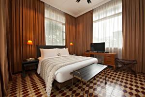 马尼拉马尼拉亨利酒店的一间卧室配有一张大床和电视