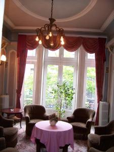 布鲁塞尔曼哈顿酒店的客厅设有桌子和大窗户