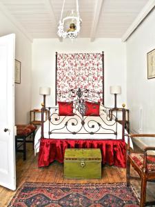 MatjiesfonteinLord Milner Hotel的一间卧室配有红色枕头的床