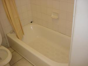 吉尔罗伊加里克法姆汽车旅馆的浴室配有白色浴缸和卫生间。