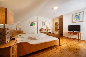 韦斯灵Il Plonner - Hotel Restaurant Biergarten的一间卧室配有一张床和一台平面电视