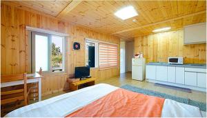 济州市格特瓦古诺瑞姆度假屋的一间带大床的卧室和一间厨房