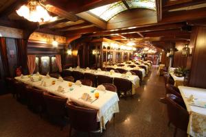 乌迪内奥勒杜伊帕尔梅酒店的餐厅里设有几排桌椅的房间