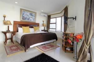 德班La Dolce Vita Umhlanga Guesthouse的一间卧室设有一张大床和一个窗户。