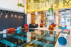 柏林柏林辉盛凯贝丽酒店式服务公寓的大堂设有色彩缤纷的椅子和玻璃地板
