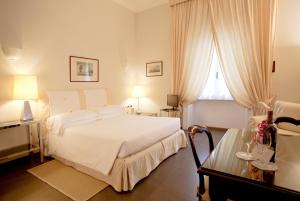 罗马阿尔德罗万迪城市套房酒店的卧室配有白色的床和窗户。