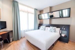 瓦伦西亚鲁发法高科技酒店的卧室配有一张白色大床和电视。