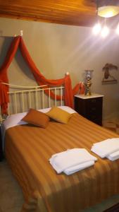 波尔塔里亚Archontiko Pantou的一间卧室配有带毛巾的床
