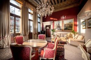 威尼斯鲁奇尼宫酒店的客厅配有吊灯和桌椅