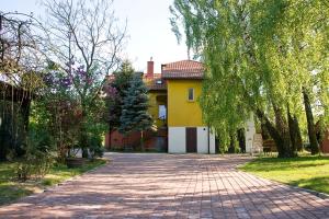 PowązkiApisoltysowka的黄色房子前面的砖路