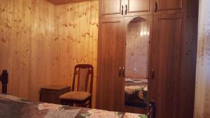 苏呼米Частный сектор的一间卧室配有一张床、一个橱柜和一把椅子