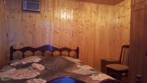 苏呼米Частный сектор的一间卧室设有一张床和木墙